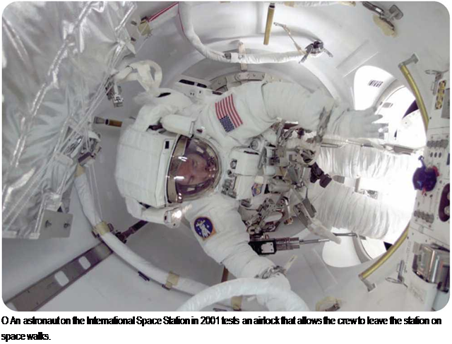 Подпись: O An astronaut on the International Space Station in 2001 tests an airlock that allows the crew to leave the station on space walks. 