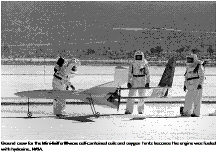 Подпись: Ground crew for the Mini-Sniffer III wore self-contained suits and oxygen tanks because the engine was fueled with hydrazine. NASA. 