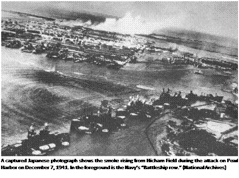 Подпись: A captured Japanese photograph shows the smoke rising from Hicham Field during the attack on Pearl Harbor on December 7, 1941. In the foreground is the Navy’s “Battleship row.” (National Archives) 