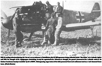 Подпись: With its landing wheels safely dug into the soil on an airdrome in Soviet Union, this Bf 109's guns are being calibrated by the “Black Men" of a Luftwaffe fighter unit. With the strength of the Jagdgruppen diminishing to only the equivalent of a Schwarm in strength, the ground personnel of the Luftwaffe units on the Eastern Front were heavily overstaffed by fall of 1941. Subsequently, large levies of the staff personnel from such units were sent on a well-deserved home leave. (Photo: Norrie.) 